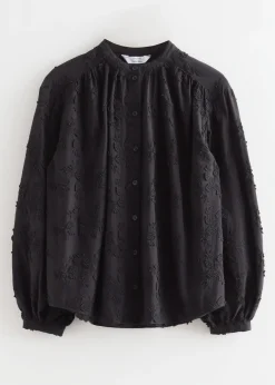 Voluminöse Bluse mit Blumenapplikation
